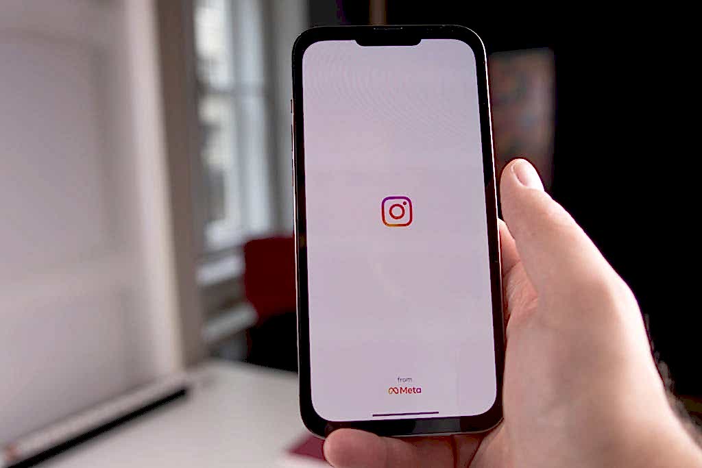 Close-up of a hand holding a smartphone displaying the Instagram app, indoors in Budapest.Meta / İnstagram Reklam Hesabı Neden Kapanır?